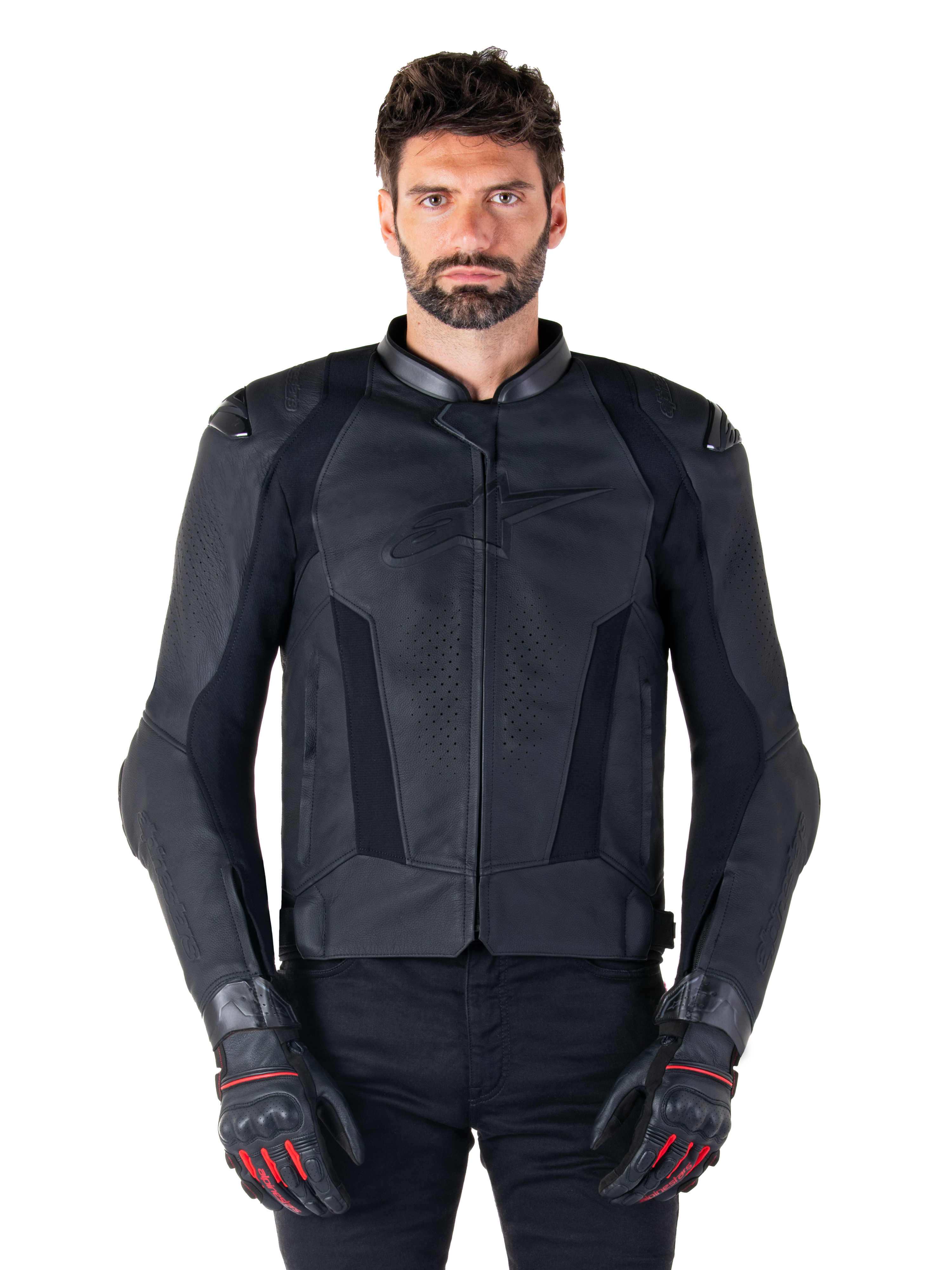 Alpinestars Missile V3 leren motorjas, zwarte motorracing jas, gedragen door model met bijpassende zwarte handschoenen en broek, voorzien van geperforeerd leer voor ventilatie, externe schoudersliders en een strak sportief ontwerp