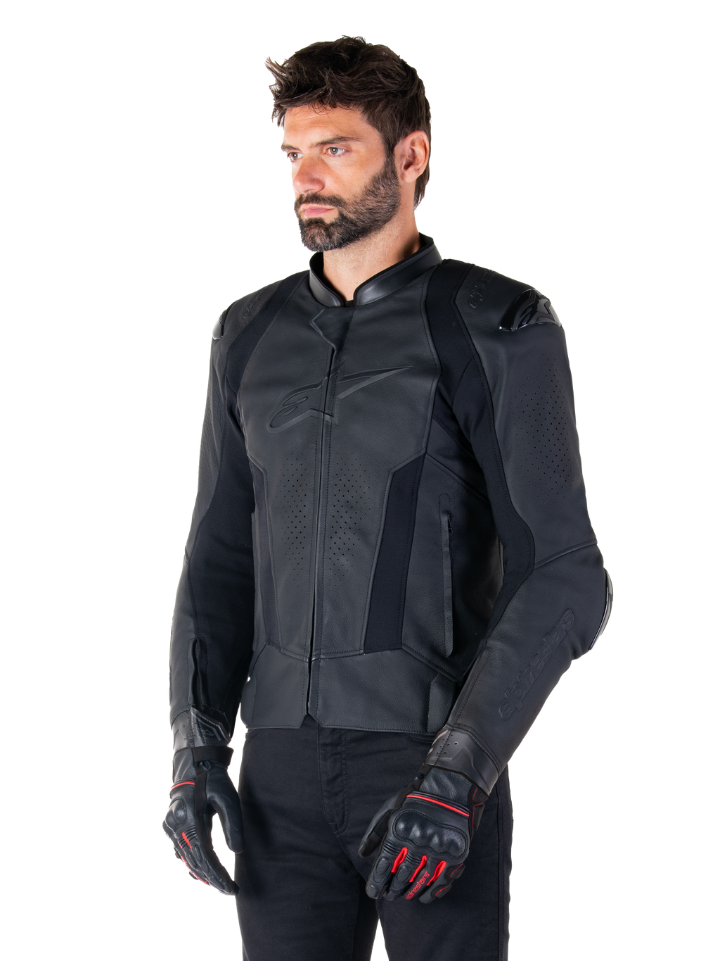 Mannelijke motorrijder met de Alpinestars Missile V3 leren jas in het zwart, premium rundleer met geperforeerde borstpanelen en externe DFS-schouderprotectoren, gecombineerd met een zwarte broek en zwart-rode racehandschoenen.
