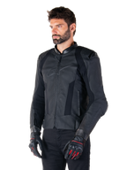 Mannelijke motorrijder met de Alpinestars Missile V3 leren jas in het zwart, premium rundleer met geperforeerde borstpanelen en externe DFS-schouderprotectoren, gecombineerd met een zwarte broek en zwart-rode racehandschoenen.