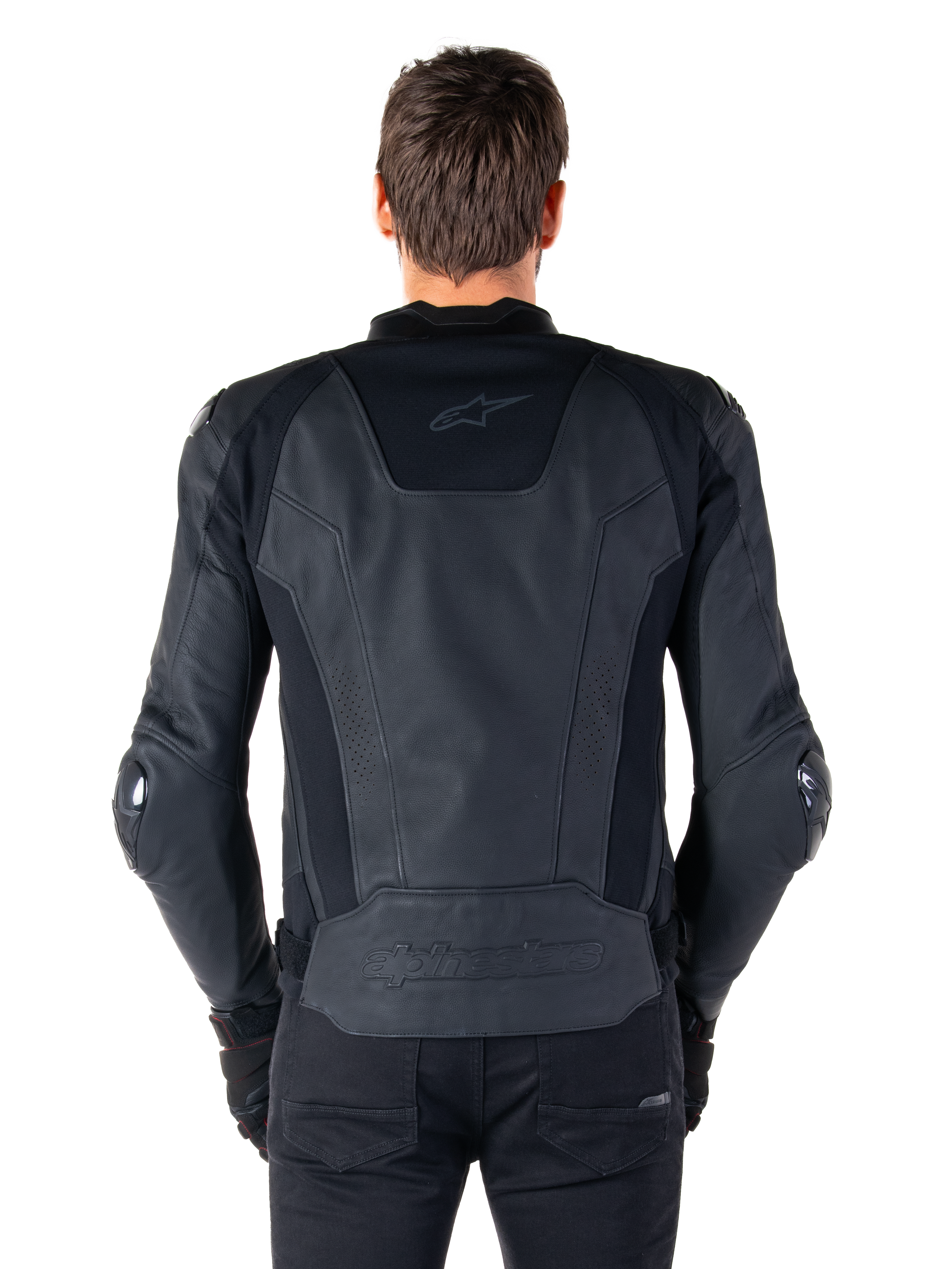 Alpinestars Missile V3 Leren Jas, achteraanzicht van een motorrijder, zwart, premium lederen constructie met technische stretchpanelen, Alpinestars-logo in reliëf op de onderrug en subtiele branding op de bovenrug, gecombineerd met zwarte broek voor een gecoördineerde racing sport-look