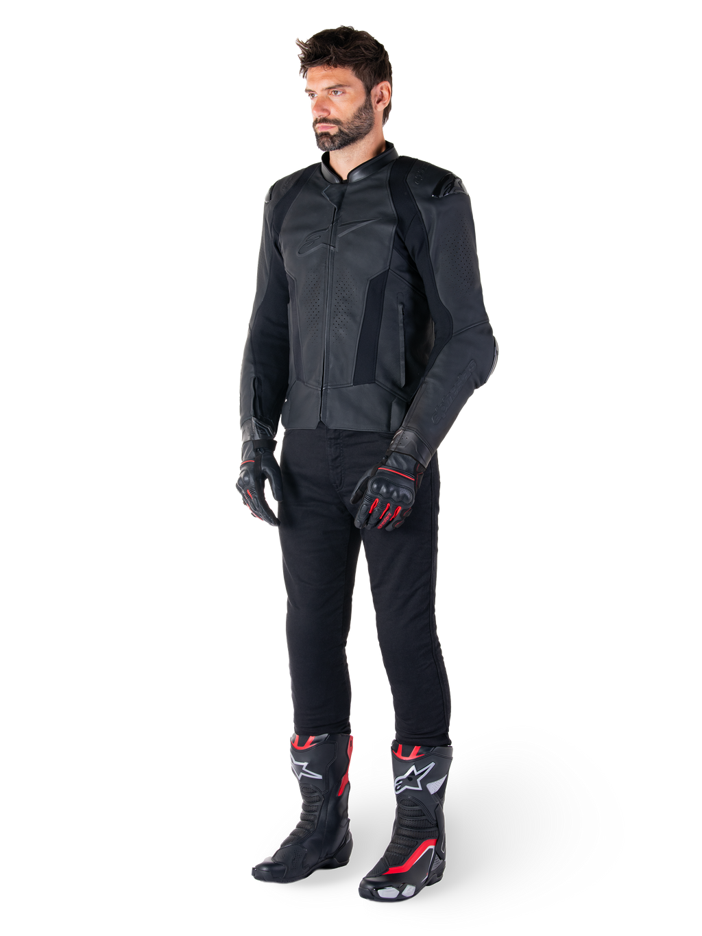 Alpinestars Missile V3 Leren Jas, zwart, gedragen door een rijder met een zwarte broek en zwart-rode racehandschoenen en laarzen, voorzien van geperforeerde leren panelen en strakke monochrome branding, professionele racing sport esthetiek
