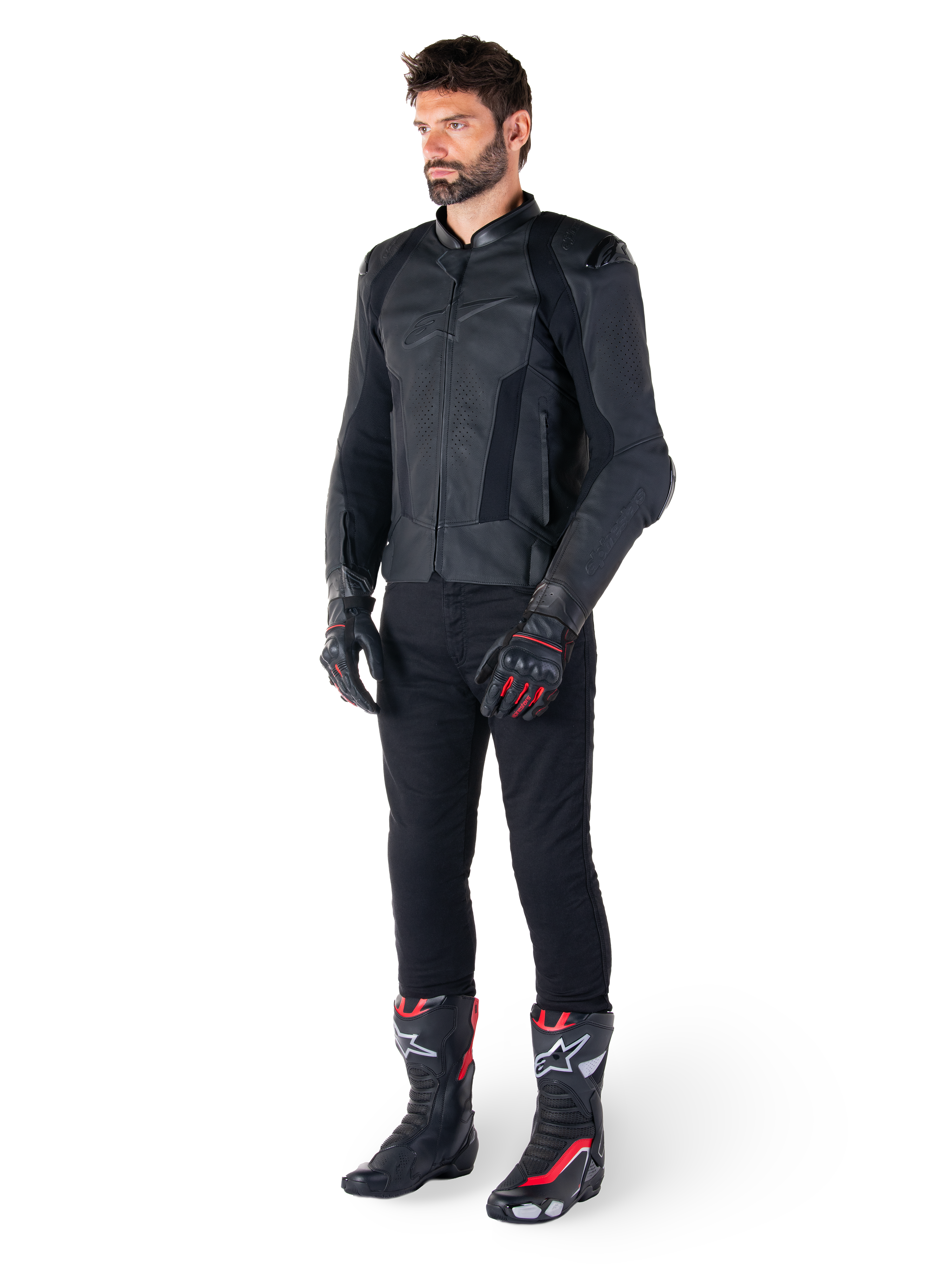 Alpinestars Missile V3 Leren Jas, zwart, gedragen door een rijder met een zwarte broek en zwart-rode racehandschoenen en laarzen, voorzien van geperforeerde leren panelen en strakke monochrome branding, professionele racing sport esthetiek