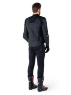 Alpinestars Missile V3 Leren Jas in het zwart, achteraanzicht op een rijder, gedragen met zwarte broek en zwart-rode racelaarzen, voorzien van een gestroomlijnde leren constructie met subtiele branding en een sportieve racepasvorm