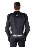 Achteraanzicht van de Alpinestars Missile V3 leren jas in zwart en wit, voorzien van het Alpinestars sterlogo op de bovenrug en merknaam op de onderrug, witte verticale strepen en externe elleboogsliders, premium lederen race-sportjas.