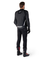 Alpinestars Missile V3 Leren Jas, zwart en wit, achteraanzicht op de rijder, met opvallende witte Alpinestars-branding op de onderrug en een klein logo op de bovenrug, gedragen met zwarte broek en racelaarzen, hoogwaardige leren constructie voor motorraces