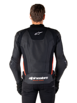 Alpinestars Missile V3 Leather Jacket, back view, premium black leather with red fluo and white accents, featuring a white star logo on the upper back and Alpinestars branding on the lower back, worn with black pants and gloves.
