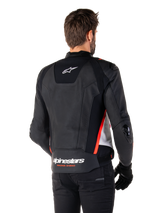 Alpinestars Missile V3 Leather Jacket, back view on a rider, Black White and Red Fluo, featuring bold Alpinestars branding and 'RACING AHEAD' text on the lower back, premium leather construction with technical stretch panels and protective TPU sliders, worn with black gloves and trousers.