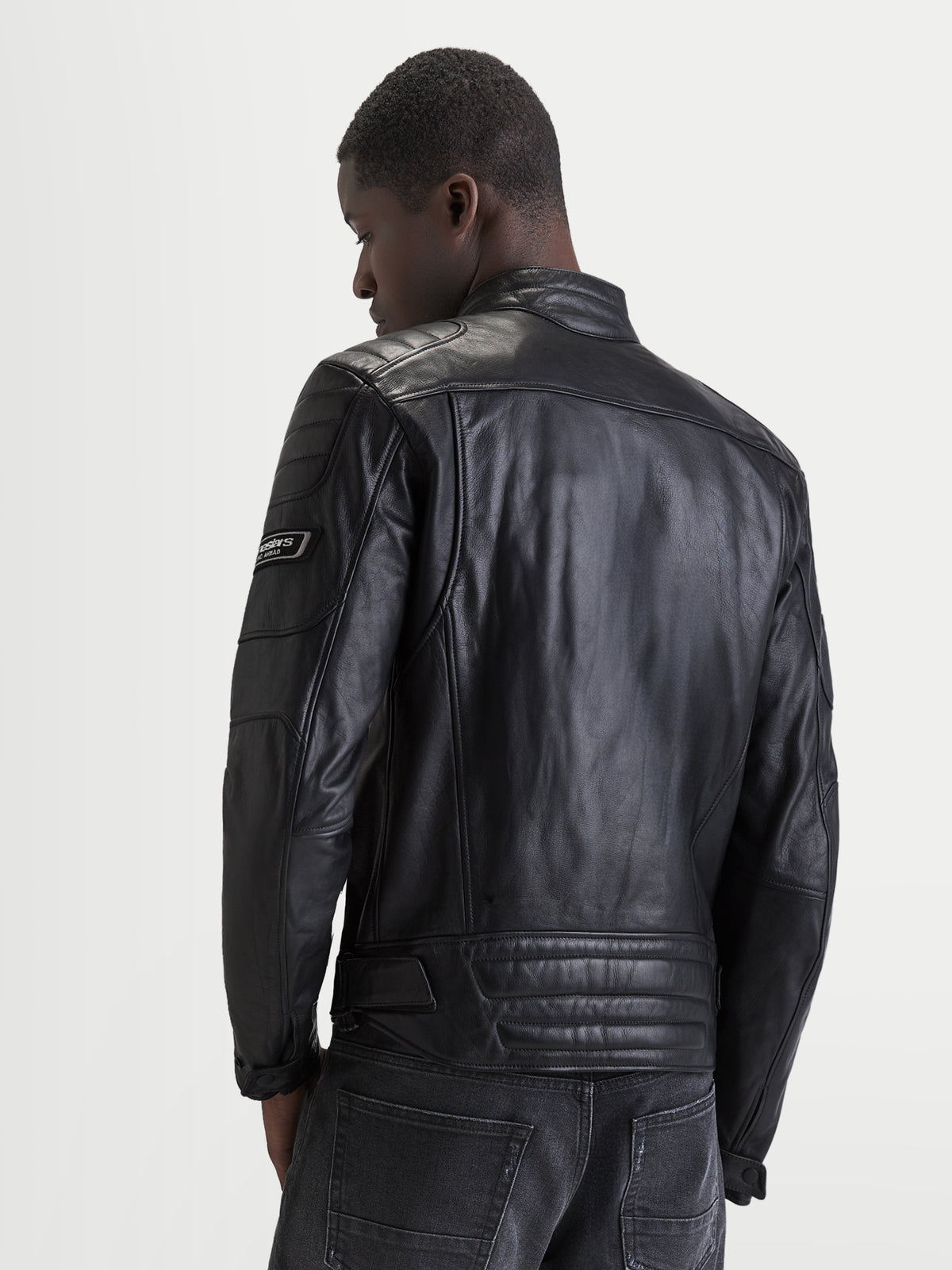 Alpinestars Revern leren jas, heren motorjas in zwart, achteraanzicht op model met verweerd volnerfleer, klassieke bikerkraag en heritage brandingdetails