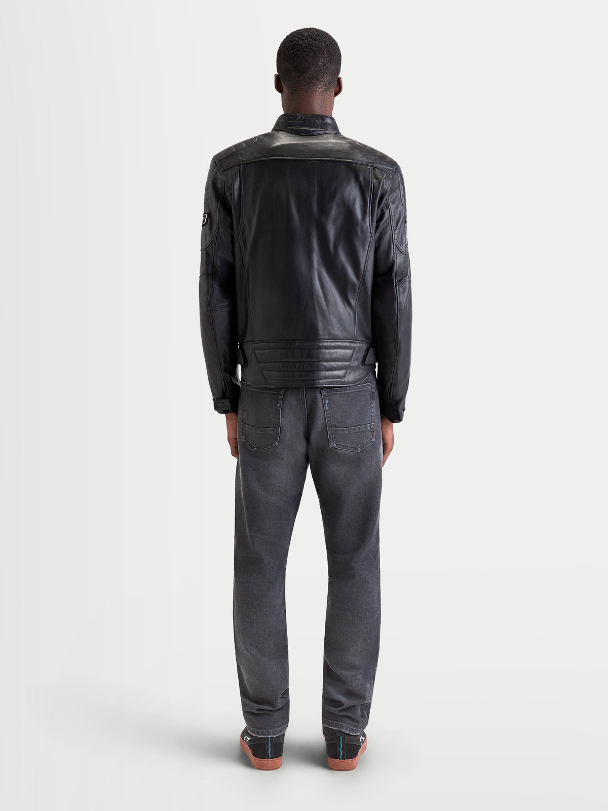 Alpinestars Revern leren jas, heren urban motorjas in zwart, achteraanzicht op een model met spijkerbroek en casual motorlaarzen, met verweerd volnerfleer