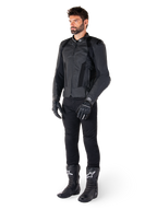 Alpinestars Missile V3 Airflow Leren Jas, zwart, gedragen door een rijder met bijpassende zwarte broek, handschoenen en laarzen, voorzien van geperforeerd rundleer voor maximale ventilatie en DFS-schouderprotectie, premium sport-motoruitrusting