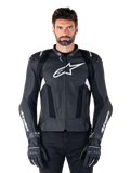 Alpinestars Missile V3 Airflow leren motorjas, zwart en wit, motorracejas met geperforeerde lederen ventilatiepanelen, groot wit sterlogo op de borst, gedragen met bijpassende handschoenen, sportief beschermend ontwerp
