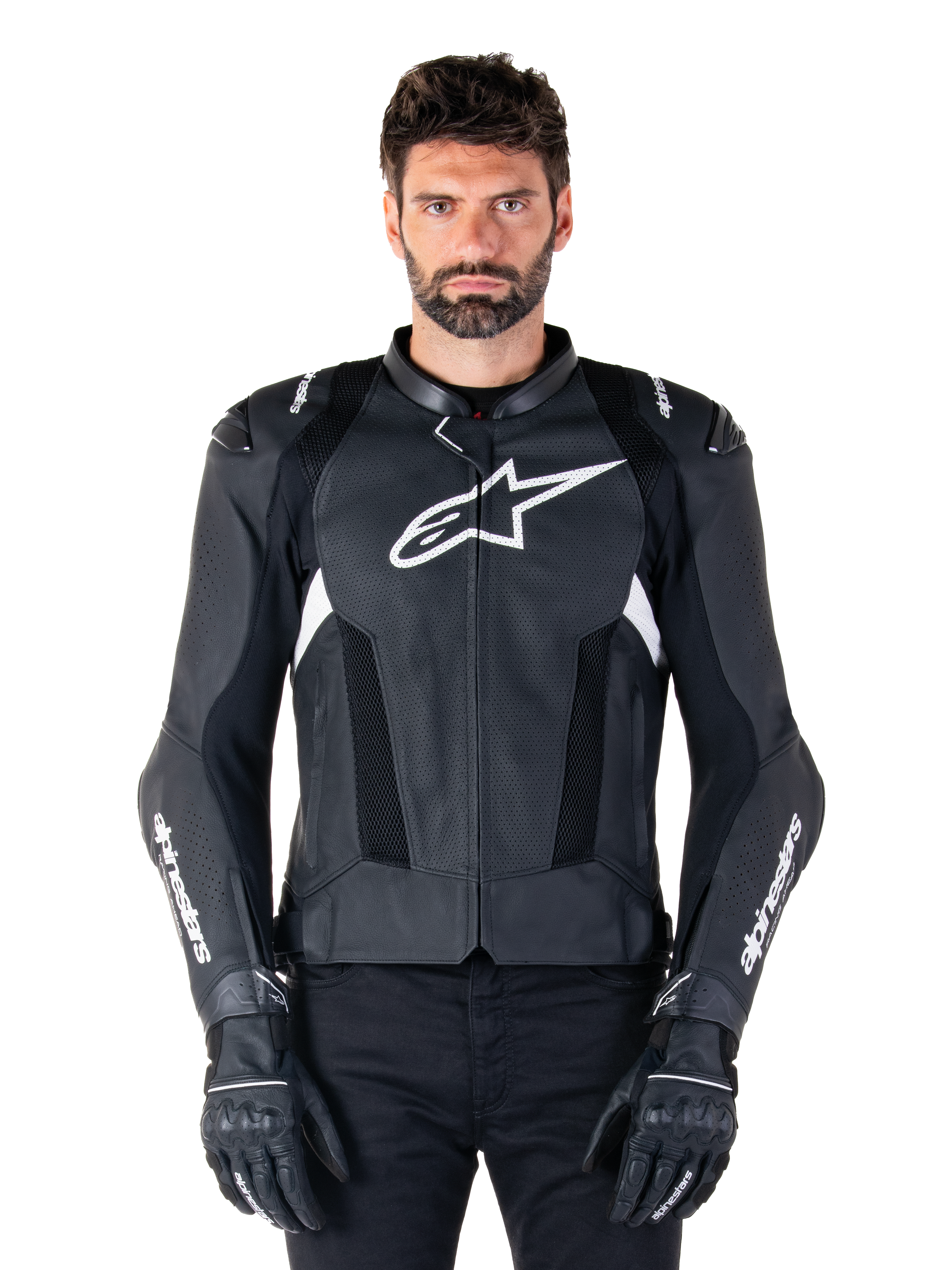 Alpinestars Missile V3 Airflow leren motorjas, zwart en wit, motorracejas met geperforeerde lederen ventilatiepanelen, groot wit sterlogo op de borst, gedragen met bijpassende handschoenen, sportief beschermend ontwerp