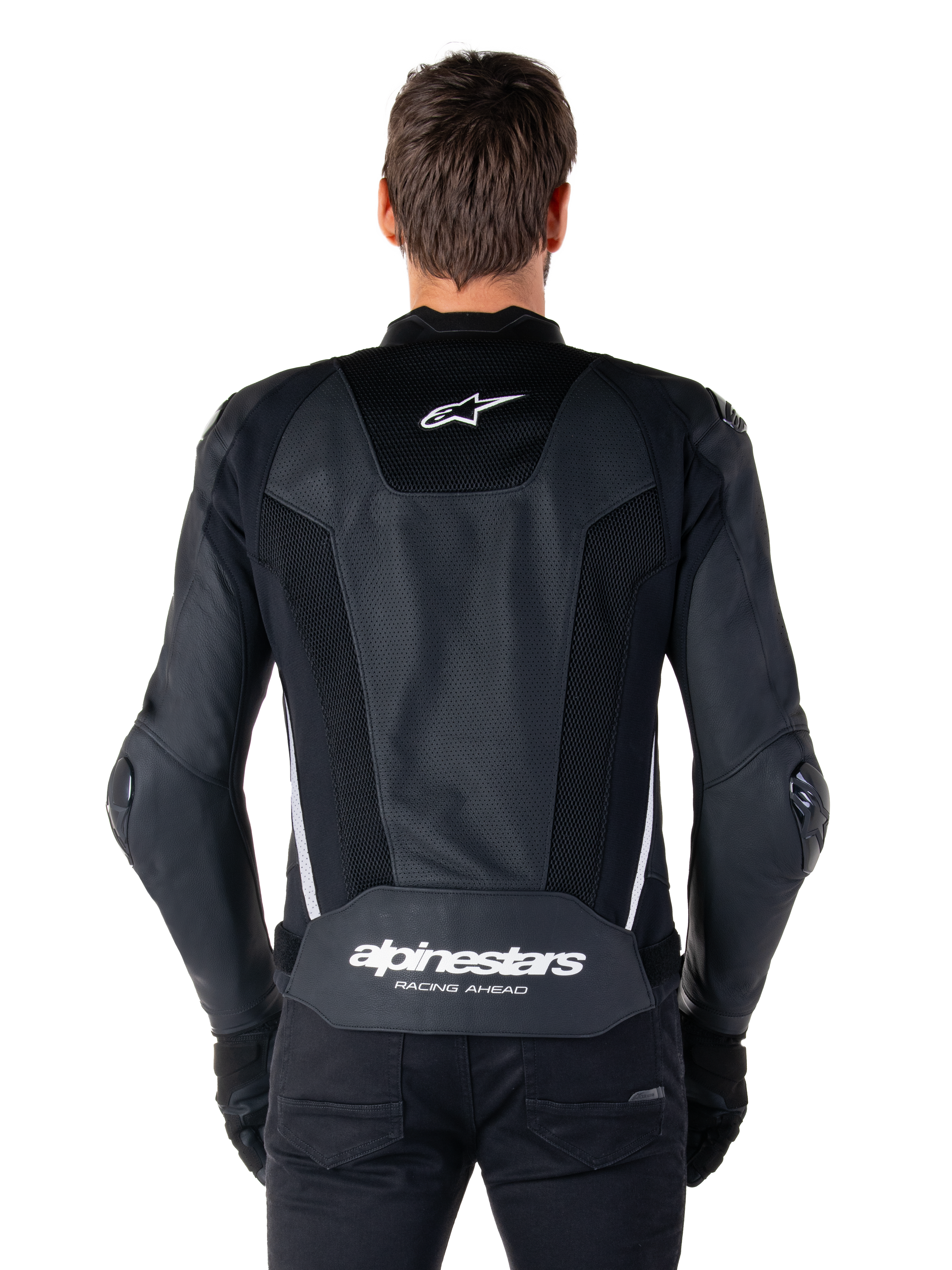 Alpinestars Missile V3 Airflow Leren Jas, zwart en wit, achteraanzicht gedragen door een rijder, met uitgebreide geperforeerde leren panelen, witte zij-accenten, Alpinestars sterlogo op de bovenrug en 'alpinestars RACING AHEAD' branding op de onderrug.