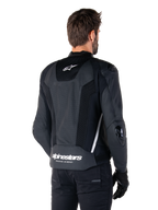 Alpinestars Missile V3 Airflow Leren Jas, zwart en wit, achteraanzicht met geperforeerd leer en mesh-panelen voor maximale ventilatie, witte Alpinestars-branding op de onderrug en sterlogo in de nek, gedragen met zwarte rijuitrusting, premium racing sportontwerp