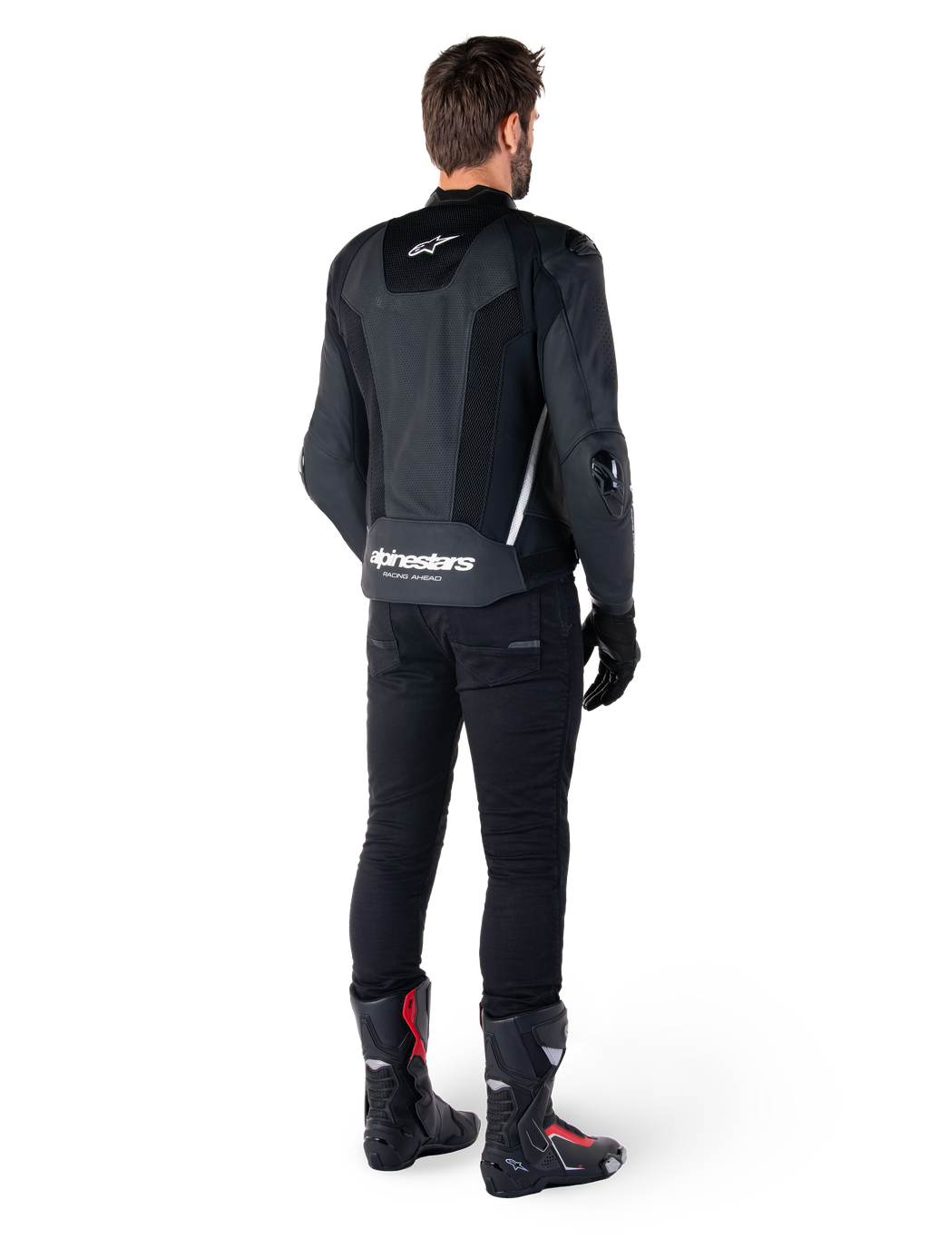 Alpinestars Missile V3 Airflow leren jas, zwart en wit, achteraanzicht gedragen met zwarte technische broek en racelaarzen, met geperforeerde leren rugpanelen en opvallende Alpinestars-branding op de onderrug