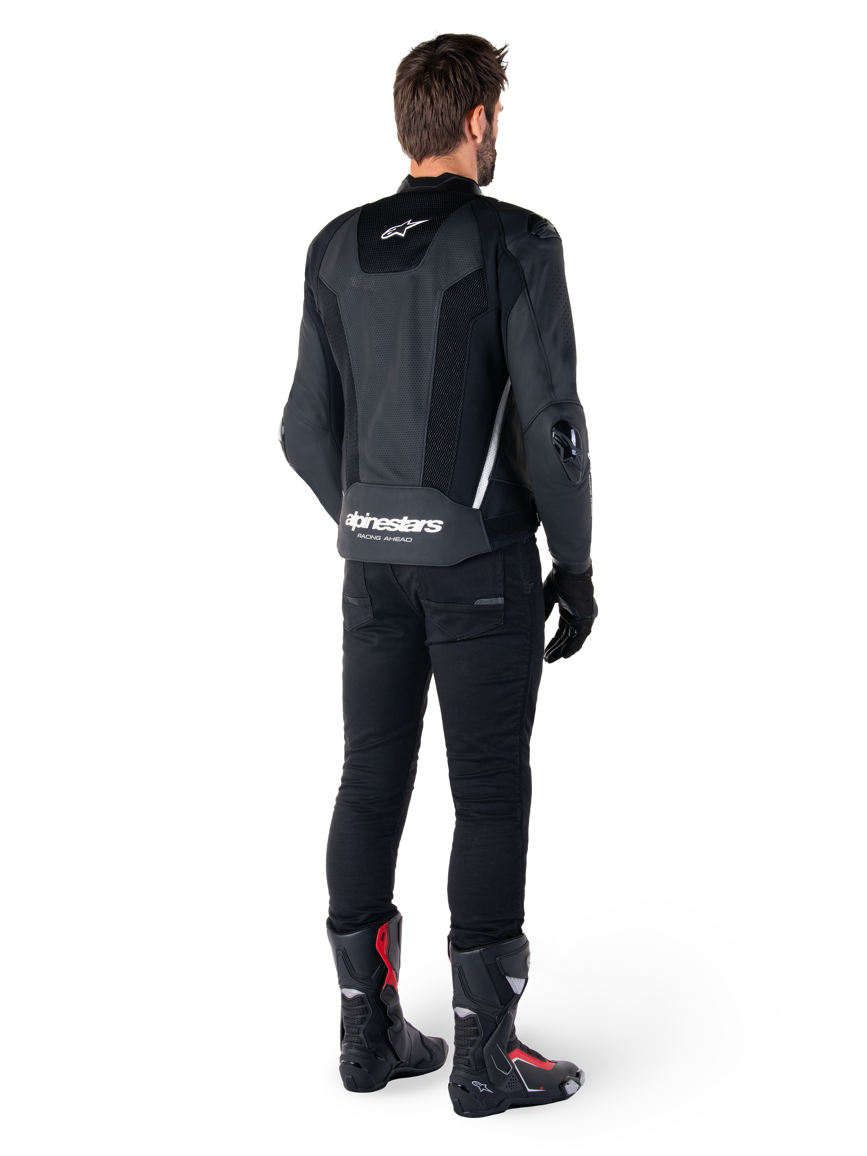 Alpinestars Missile V3 Airflow leren jas, zwart en wit, achteraanzicht gedragen met zwarte technische broek en racelaarzen, met geperforeerde leren rugpanelen en opvallende Alpinestars-branding op de onderrug