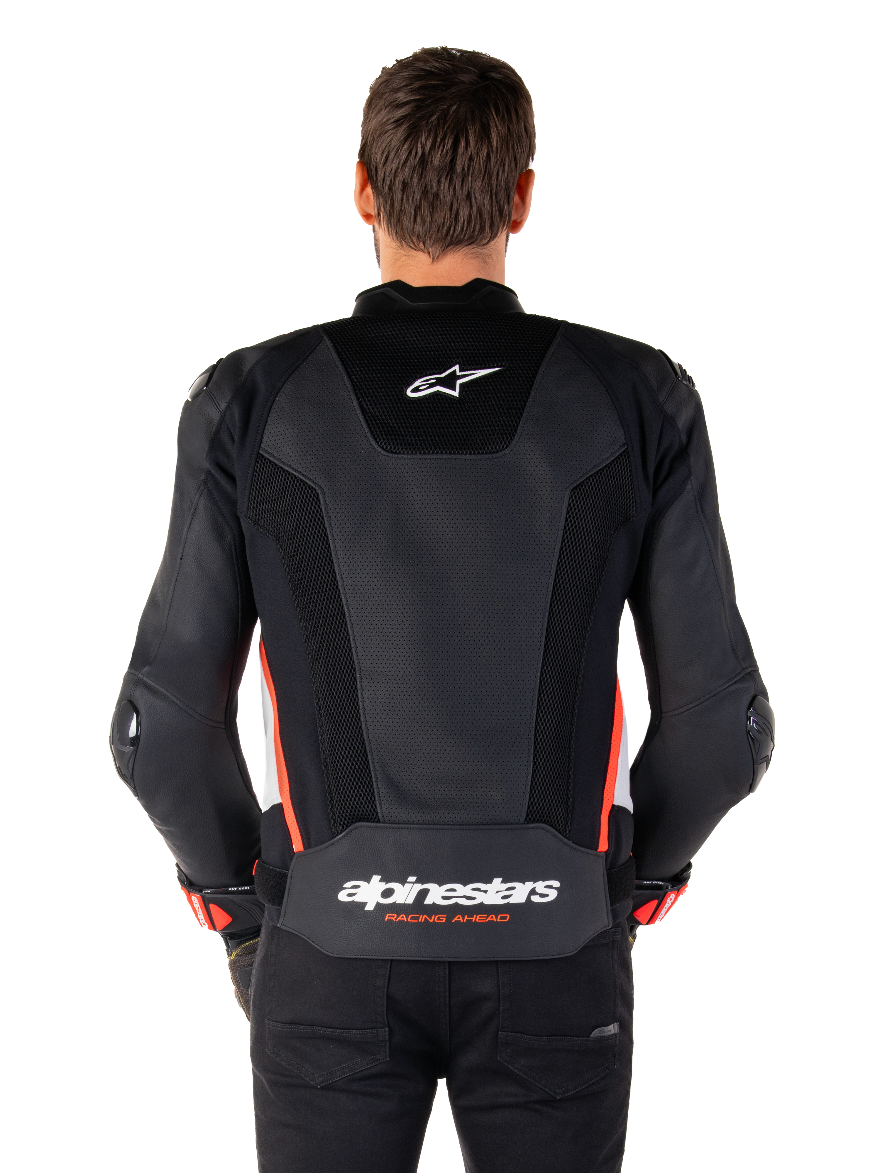 Achteraanzicht van een persoon die de Alpinestars Missile V3 Airflow Leather Jacket in Black White Red Fluo draagt, voorzien van uitgebreide geperforeerde lederen panelen voor ventilatie, een klein Alpinestars-logo op de bovenrug en opvallende 'alpinestars RACING AHEAD' branding aan de onderkant van de rug.