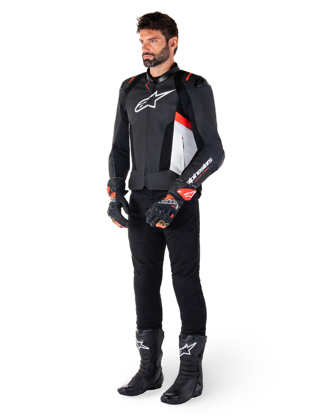 Alpinestars Missile V3 Airflow Leren Jas, zwart wit en rood fluo, gedragen door mannelijk model met zwarte broek, racehandschoenen en laarzen, geperforeerd leer voor ventilatie, wit logo op de borst, premium race- en sportprestaties