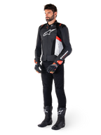 Alpinestars Missile V3 Airflow Leren Jas, zwart wit en rood fluo, gedragen door mannelijk model met zwarte broek, racehandschoenen en laarzen, geperforeerd leer voor ventilatie, wit logo op de borst, premium race- en sportprestaties