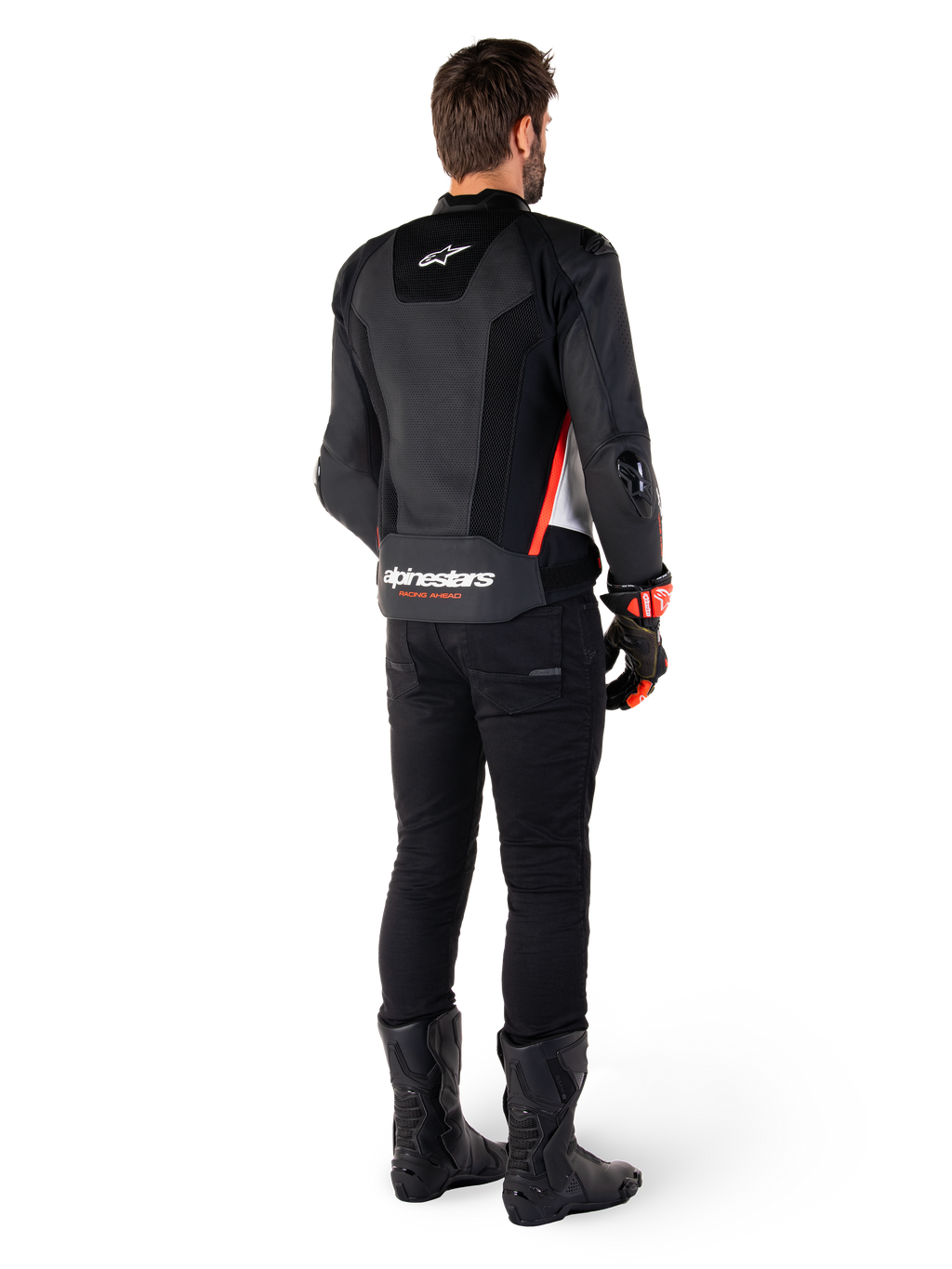 Rijder van achteren gezien met de Alpinestars Missile V3 Airflow leren jas in Black White Red Fluo, gecombineerd met een zwarte broek en zwarte laarzen, voorzien van uitgebreid geperforeerd leer voor ventilatie, DFS schouderprotectie en opvallende Alpinestars branding op de onderrug.