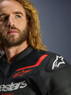 Alpinestars GP Force V2 Leren Jas, zwart en fluo rood, gedetailleerde close-up van de schouder en borst, voorzien van wit Alpinestars-logo en GP Lite Evo DFS schouderbeschermer, premium leren constructie