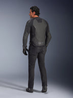 Achteraanzicht van een model die de Alpinestars GP Force V2 leren jas draagt in Black Black, voorzien van een meerpanelige leren constructie en sportieve pasvorm, gecombineerd met een zwarte motorbroek, handschoenen en laarzen voor een complete, op motorracen geïnspireerde look.