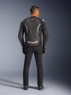 Alpinestars GP Force V2 Leren Jas, zwart en wit, achteraanzicht, gedragen door een rijder met zwarte broek en handschoenen, met groot wit logo op de onderrug en rode accenten, hoogwaardige rundleer constructie voor motorfiets weguitrusting