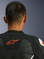 Alpinestars GP Force V2 Leren Jas, zwart en wit, close-up achteraanzicht van de nek en schouders, rood Alpinestars-logo, premium leer met textiel stretchpanelen, sportief performance-ontwerp