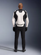 Alpinestars GP Force V2 Leather Jacket, White and Black, rear view showing large white back panel with Alpinestars logo and 'RACING AHEAD' text, worn with black riding pants and gloves, sport motorcycle gear design