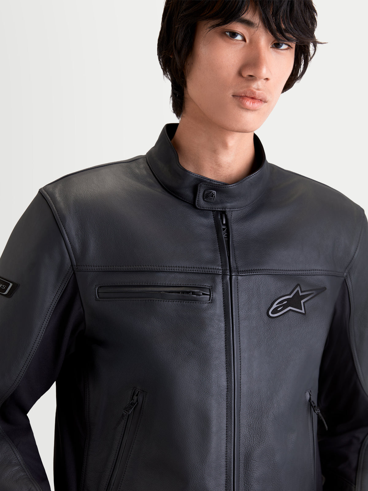 Alpinestars Maver X leren motorjas voor heren, urban contemporary motorjas in het zwart, close-up van de voorkant op een model in premium leer met zakken met ritssluiting en een opstaande kraag