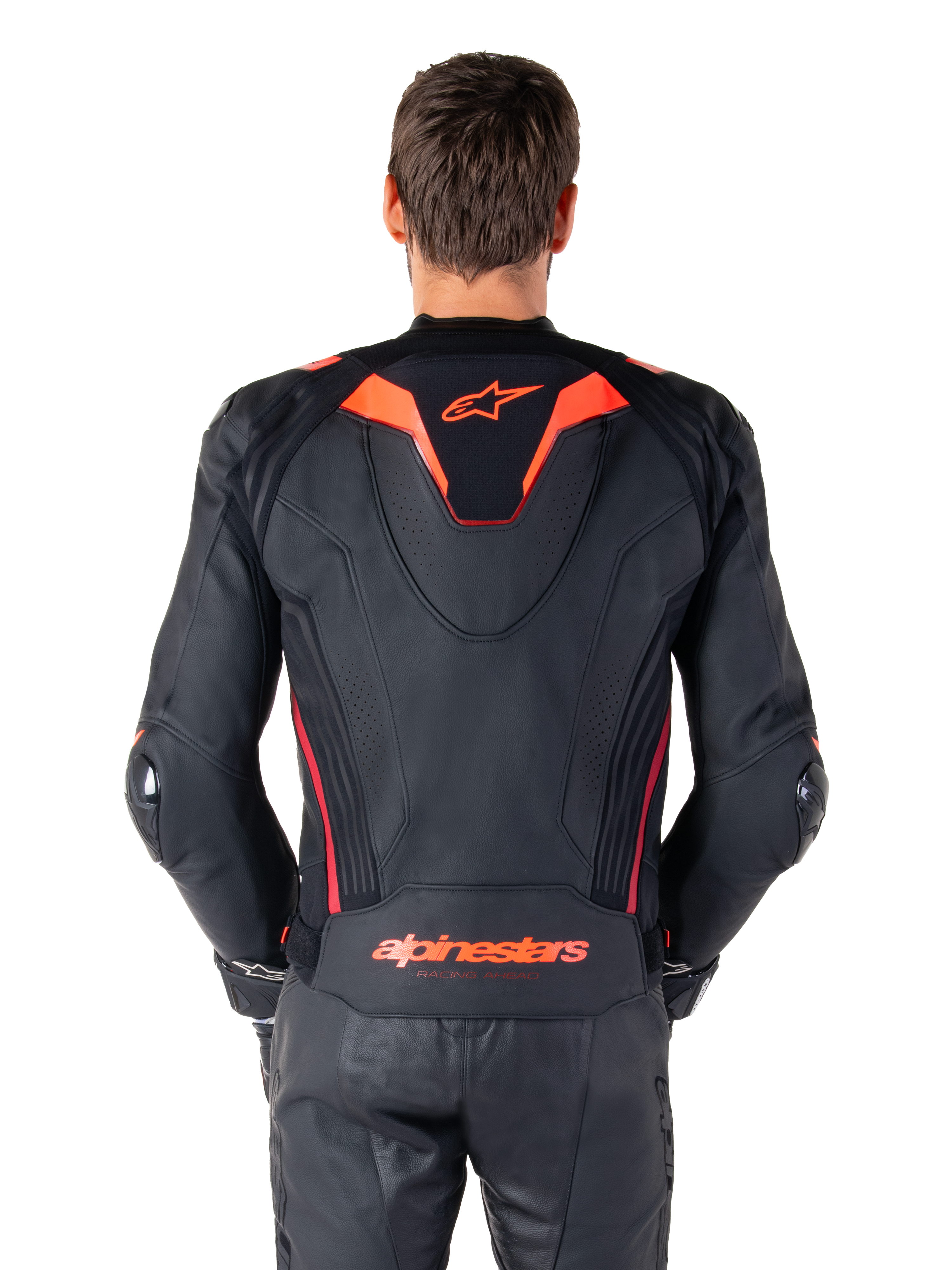 Alpinestars Missile V3 Ignition leren jas, achteraanzicht, zwart met Red Fluo en Dark Red accenten, voorzien van een sportieve aero-hump, Alpinestars-branding op de rug, gedragen met bijpassende zwarte leren motorbroek, hoogwaardige motorrace-uitrusting