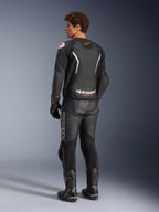 Alpinestars GP Force V2 Air leren jas, zwart en wit, achteraanzicht op model met geperforeerd rugpaneel voor ventilatie, witte branding en rood sterlogo, gedragen met bijpassende leren racebroek, handschoenen en laarzen