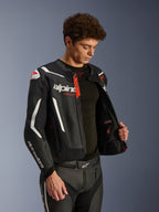 Alpinestars GP Force V2 Air Leren Jas, zwart en wit met rode accenten, geperforeerde leren constructie, opengeritst om de binnenkant en zwarte basislaag te tonen, gecombineerd met bijpassende leren broek, professionele studio-opname van motorkleding