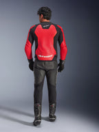Alpinestars GP Force V2 Air Leren Jas, achteraanzicht van een motorrijder, rood en zwart, grote geperforeerde panelen, wit Alpinestars-logo op de rug, zwarte leren motorbroek en racelaarzen