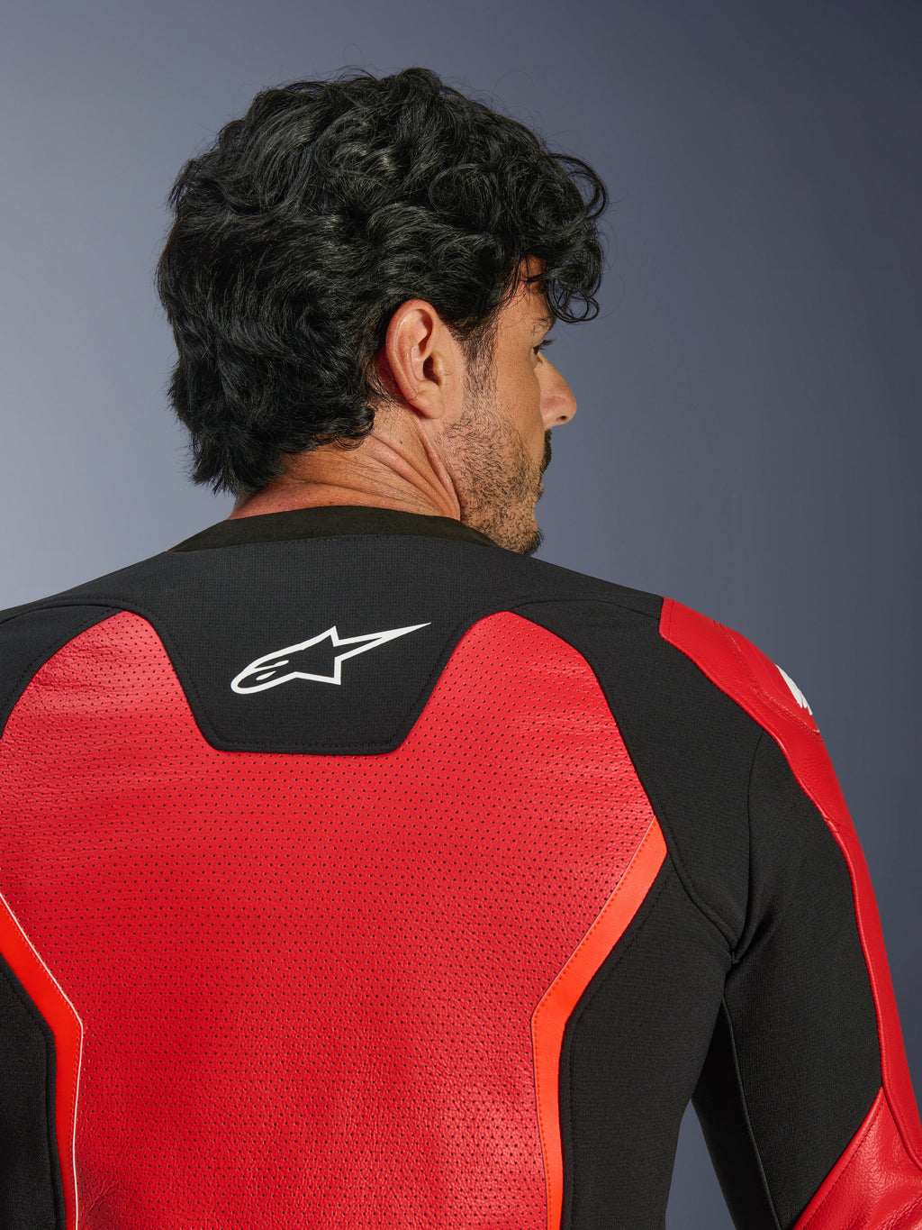 Alpinestars GP Force V2 Air Leren Jas, rood en zwart, close-up achteraanzicht met uitgebreid geperforeerd leer voor luchtstroom, zwart stretchpaneel met wit Astars-logo, sportieve motorjas