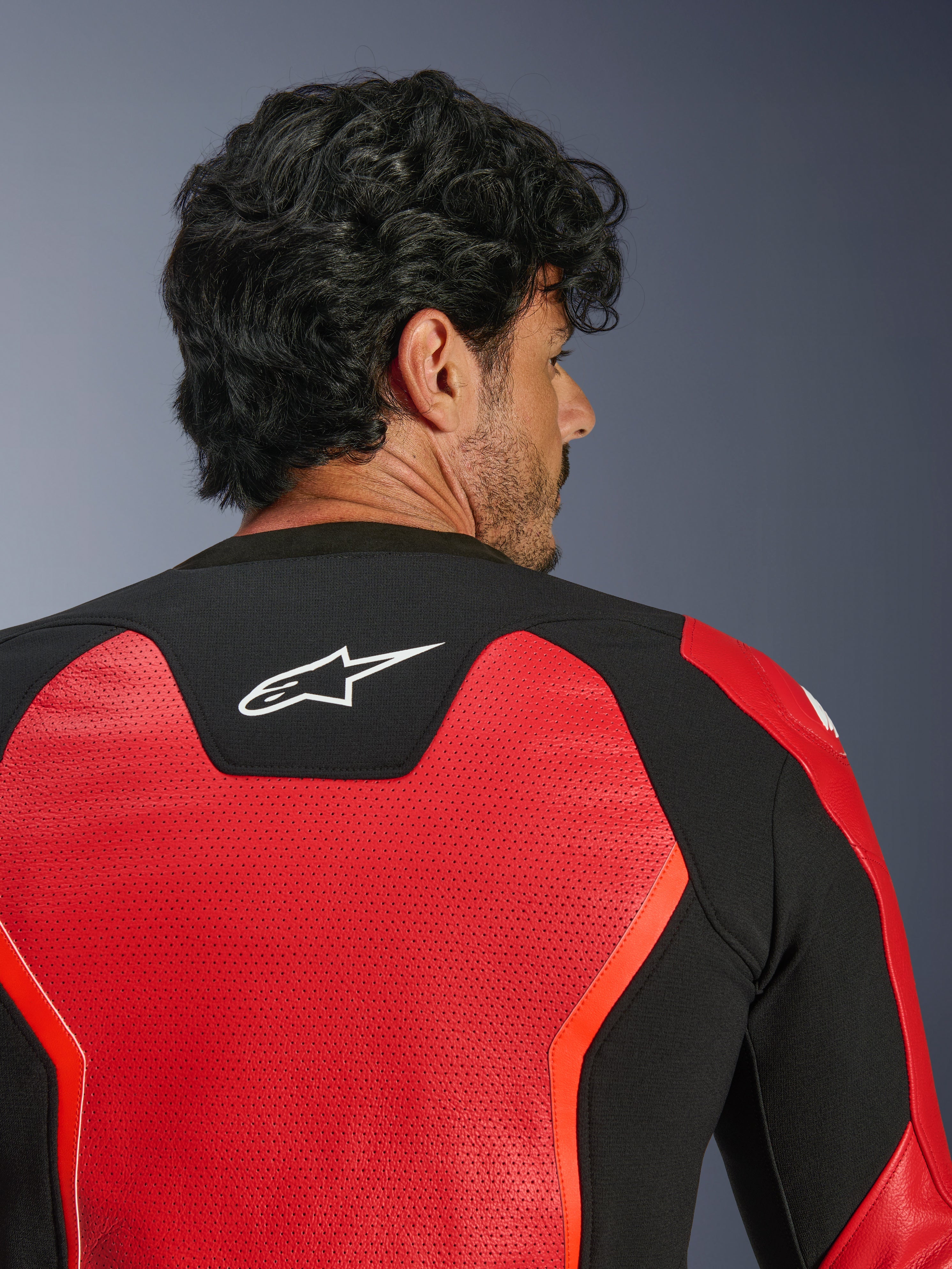Alpinestars GP Force V2 Air Leren Jas, rood en zwart, close-up achteraanzicht met uitgebreid geperforeerd leer voor luchtstroom, zwart stretchpaneel met wit Astars-logo, sportieve motorjas