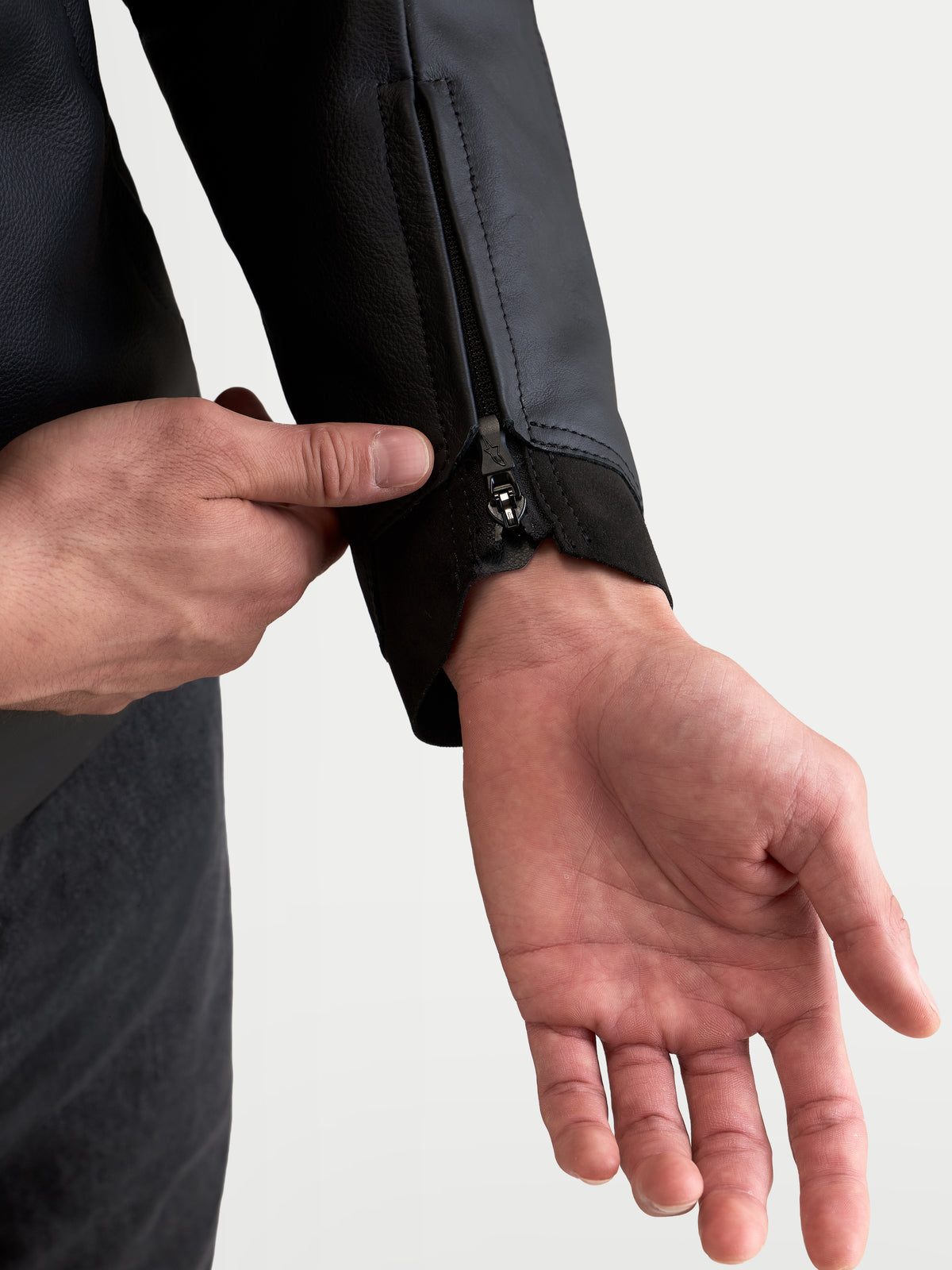 Alpinestars Caliber V 2 leren jas, detailopname van de rits bij de mouwboord en ergonomische rand, zwart, premium rundleer