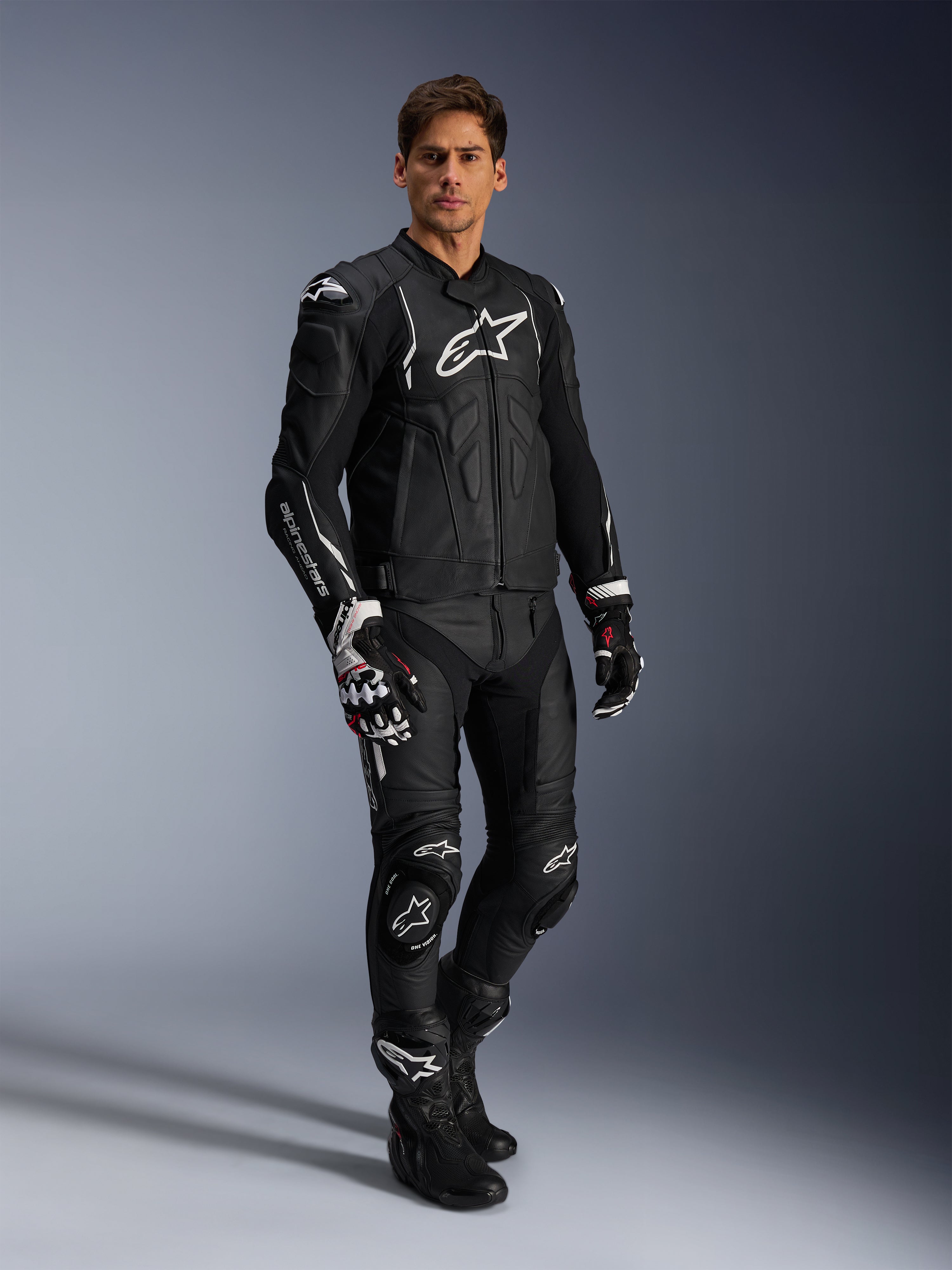 Alpinestars Missile V3 leren broek en bijpassende zwarte leren jas, volledig motorracepak, zwart met witte Alpinestars-branding op de borst en knieën, inclusief professionele racehandschoenen en laarzen, strakke beschermende kleding voor op de weg en het circuit.