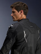 Alpinestars Dusk Leren Jas, zwart met witte accenten, achteraanzicht op model, voorzien van DFS schouderprotectoren met Alpinestars-logo, accordeon lederen stretchpanelen voor bewegingsvrijheid en 'DUSK' branding op de bovenrug, premium runderleren motorjas voor weg- en sportgebruik