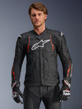 Alpinestars Dusk Airflow leren motorjas, zwart met fluorescerend rode en witte accenten, lederen motorracejas voorzien van uitgebreide perforaties voor ventilatie, wit logo op de borst en externe schoudersliders, gedragen door een model met bijpassende racehandschoenen