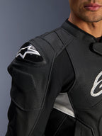 Alpinestars Dusk Airflow Leren Jas, zwart en wit, close-up van de schouder en borst, voorzien van geperforeerd leer voor ventilatie, DFS-schouderbescherming met wit Alpinestars-logo, sportief ontwerp.