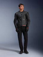 Alpinestars GP Plus R V4 Airflow leren jas, zwart, gedragen door een mannelijk model met bijpassende zwarte handschoenen en broek, voorzien van geperforeerde leren panelen, een groot tonaal sterlogo op de borst en een strakke sportieve pasvorm