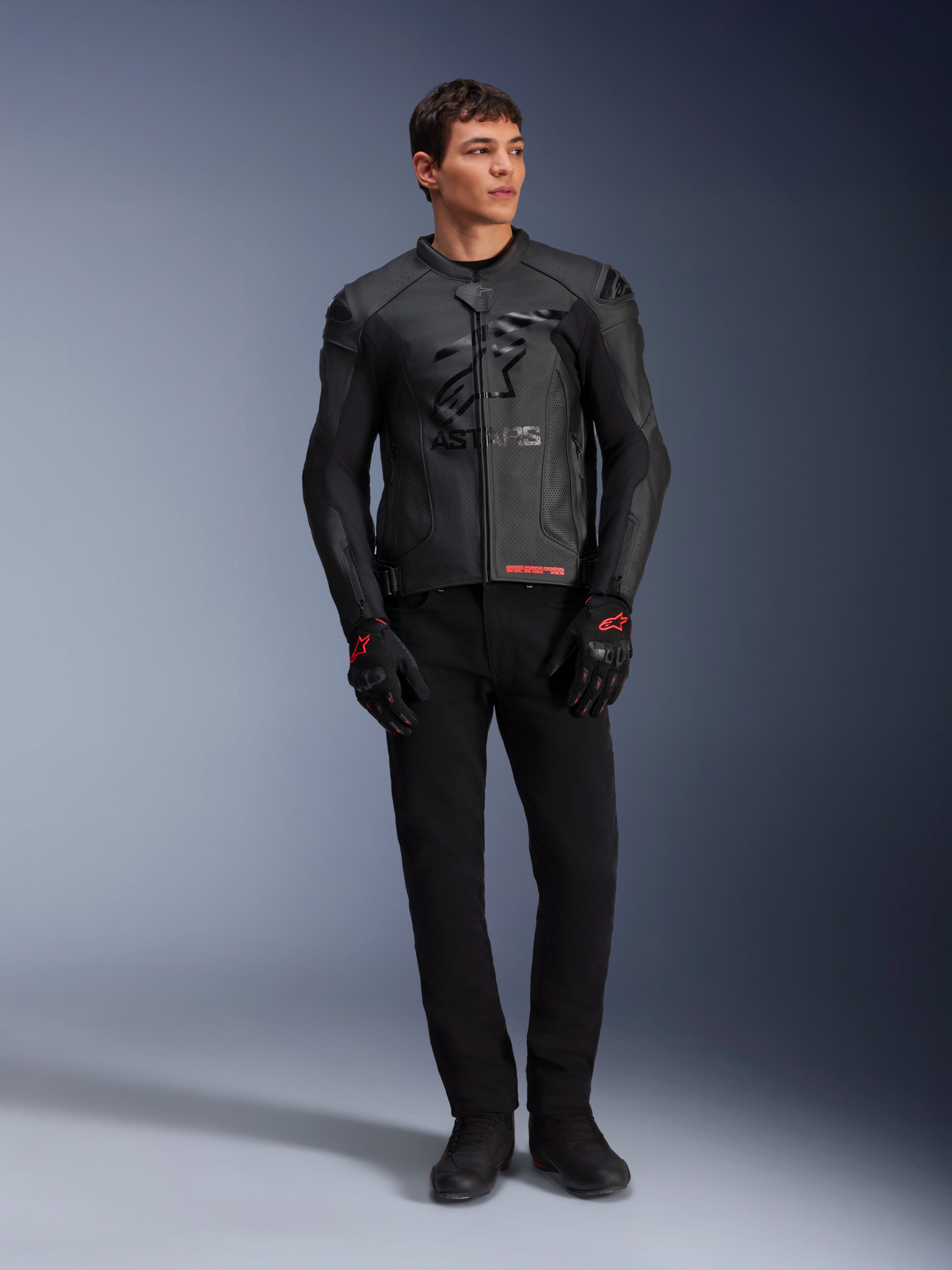 Alpinestars GP Plus R V4 Airflow leren jas, zwart, gedragen door een mannelijk model met bijpassende zwarte handschoenen en broek, voorzien van geperforeerde leren panelen, een groot tonaal sterlogo op de borst en een strakke sportieve pasvorm