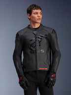 Alpinestars GP Plus R V4 Airflow leren jas, zwarte motorjas met geperforeerd leer, voorzien van prominent ASTARS-logo op de borst en DFS-schouderbescherming, gedragen met zwart-rode handschoenen