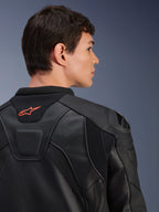 Alpinestars GP Plus R V4 Airflow leren jas, zwart, close-up achteraanzicht op een model, voorzien van geperforeerd leer van racekwaliteit, technische stretchpanelen en een klein oranje Alpinestars-logo op de kraag, professionele motorkleding