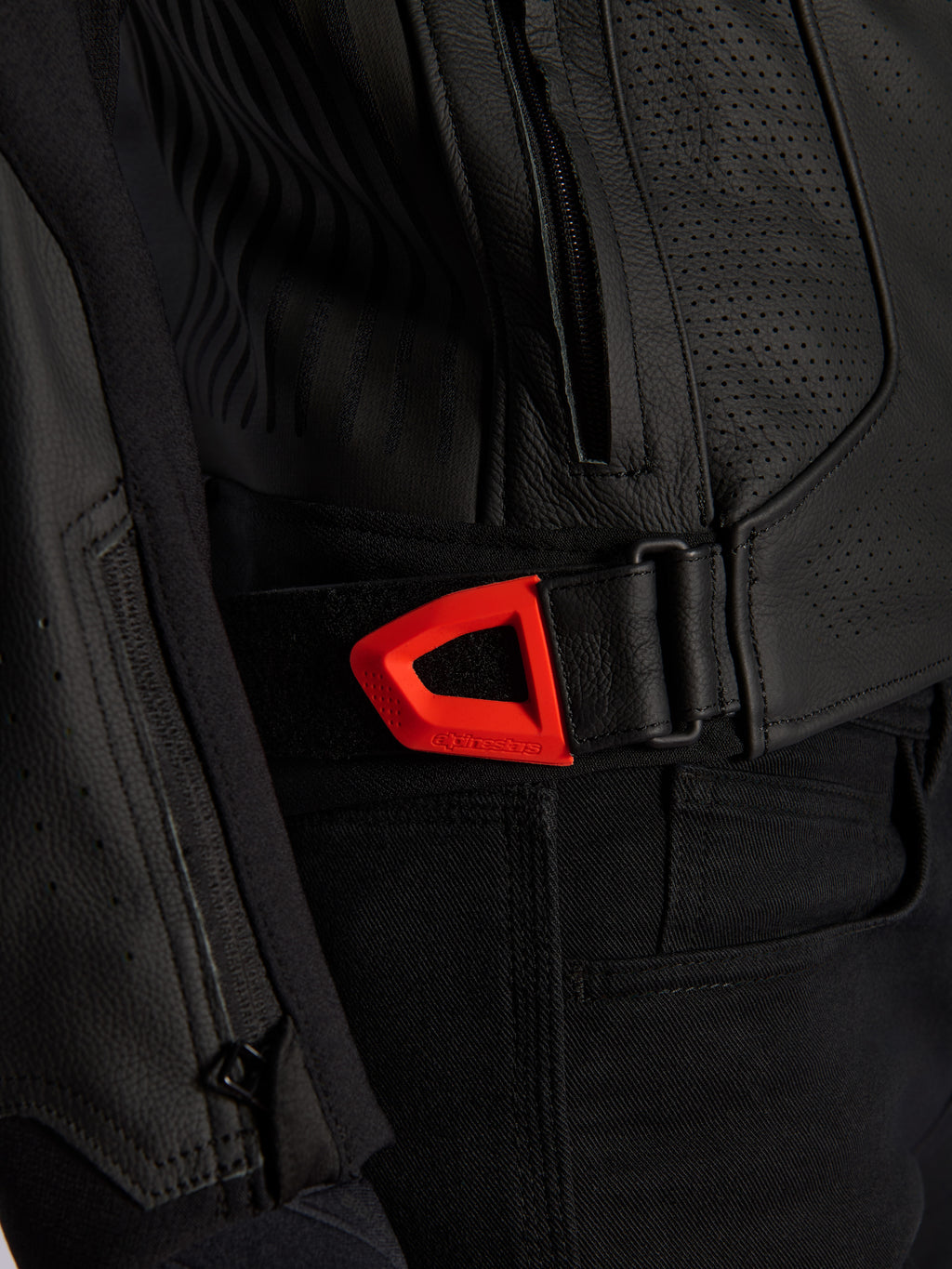 Alpinestars GP Plus R V4 Airflow leren jas close-up, zwart geperforeerd leer met een opvallende rood fluo klittenband verstelband voor de taille, voorzien van een zijzak met ritssluiting en ergonomische panelen met textuur