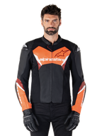 Alpinestars Faster V3 Leather Jacket, Sport Motorcycle Jacket, Black and Red Fluo, worn by a male model with black riding gloves and pants, featuring bold Alpinestars branding on chest and forearms, premium leather construction for road riding.