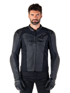 Alpinestars Faster V3 leren jas, zwarte motorjas, hoogwaardig leer met HRSF-stretchpanelen, slanke sportieve pasvorm, versterkte schouders met protectoren, gedragen met zwarte handschoenen, professionele uitrusting voor rijden op de weg