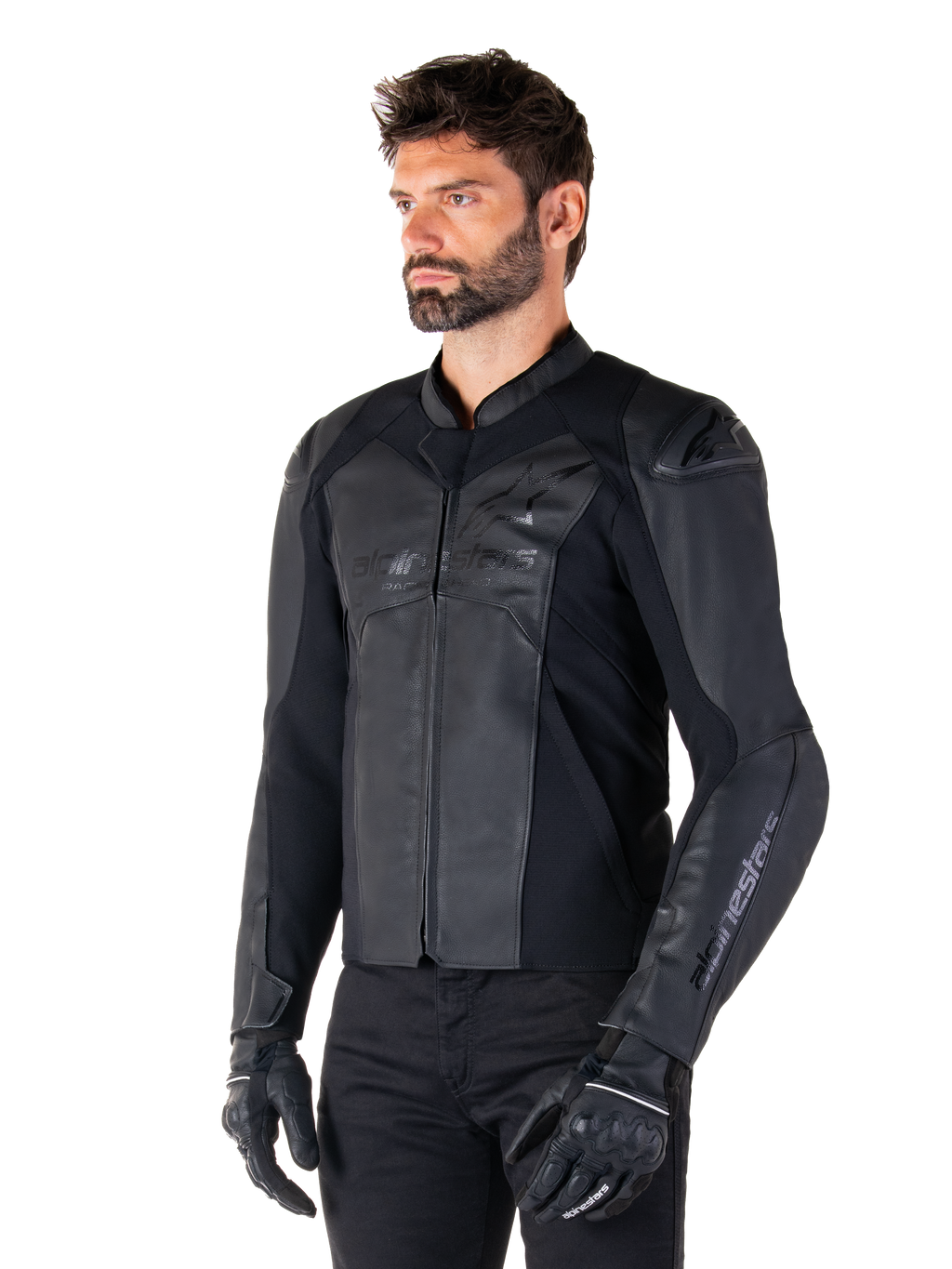 Alpinestars Faster V3 Leren Jas, sportief motorjack, zwart zwart, gedragen door een mannelijk model met zwarte broek en handschoenen, hoogwaardige leren constructie met stretchpanelen en DFS GP Lite schouderbeschermers, strak en modern sportief silhouet