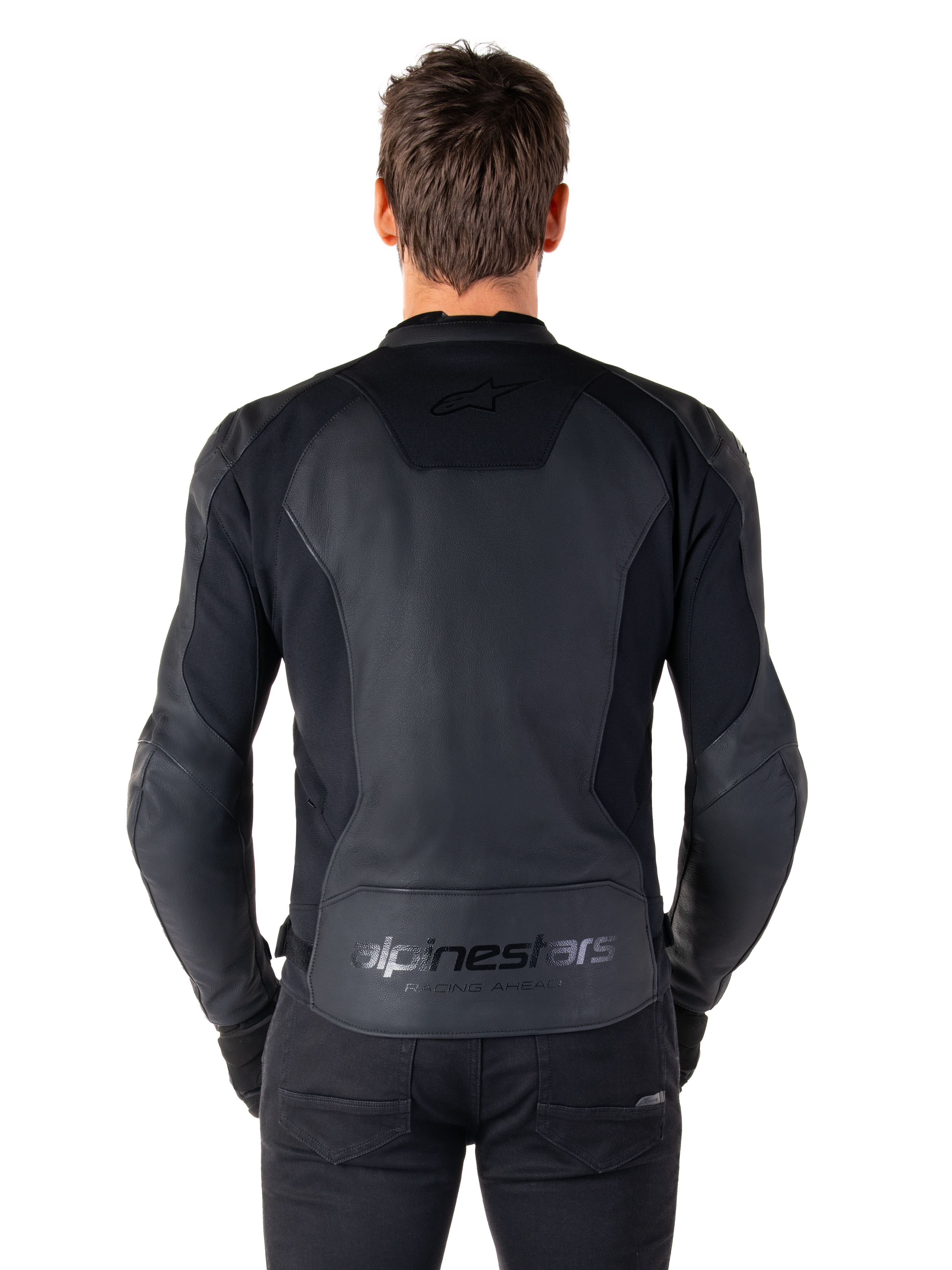 Achteraanzicht van een man die de Alpinestars Faster V3 Leren Jas in Black Black draagt, met premium lederen panelen en flexibele stretch-inzetten, subtiele 'alpinestars' en 'RACING AHEAD' branding op de onderrug, atletische sportpasvorm voor motorrijden.